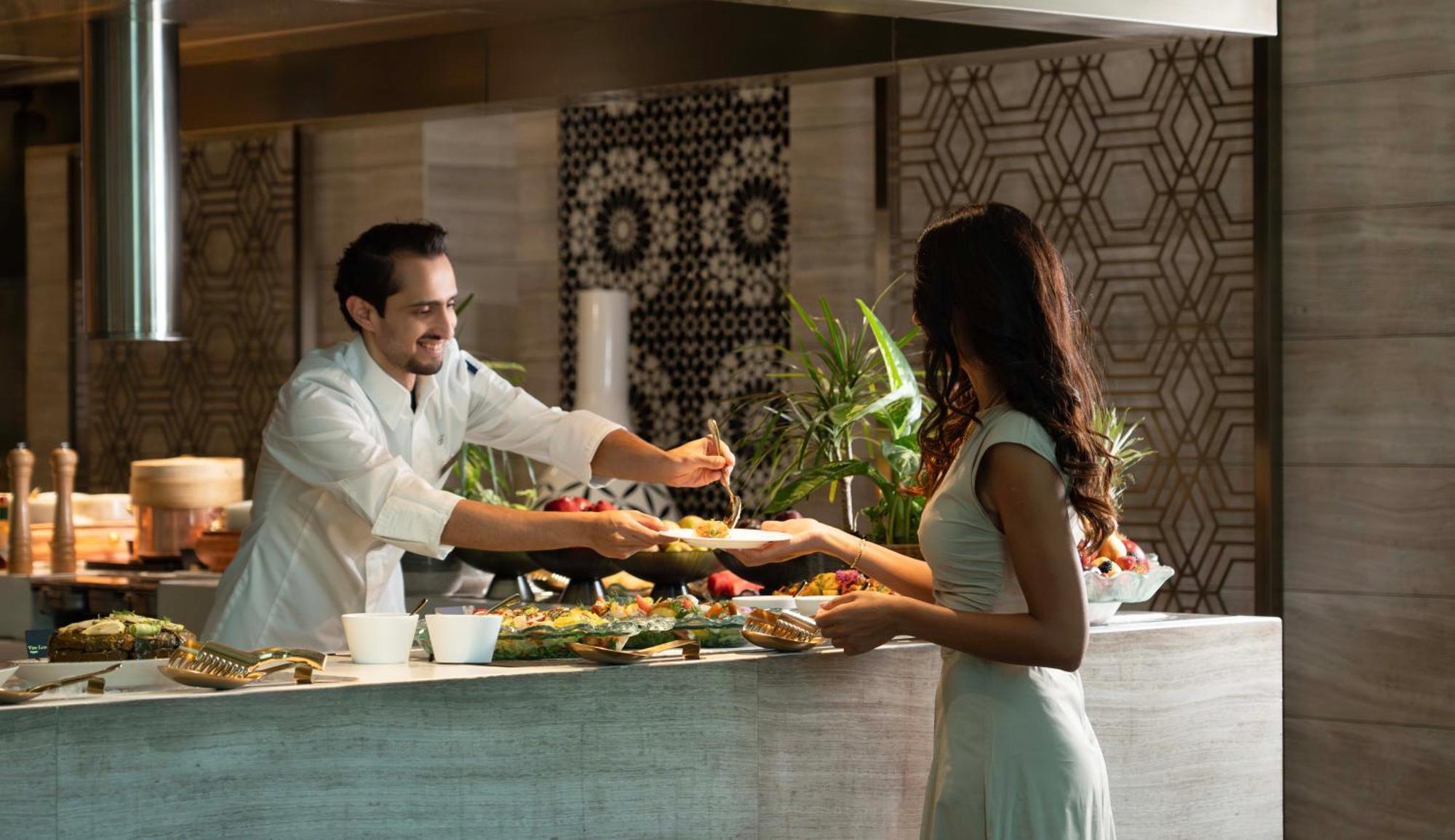 Fairmont Riyad Dış mekan fotoğraf A chef serving a guest at the buffet